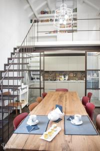 a dining room with a wooden table and a staircase at Arcipelago 37 in Cagliari