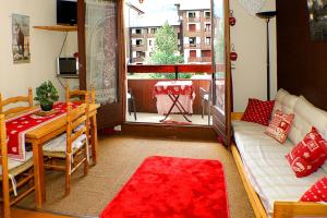 a living room with a couch and a table and a window at Studio Résidence Glières in Bourg-Saint-Maurice