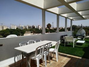 a white table and chairs on the roof of a building at Cohen's Jaffa Rooms in Tel Aviv