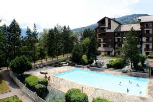 a large swimming pool with people in it next to a building at Studio Résidence Glières in Bourg-Saint-Maurice