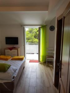 a bedroom with a bed and a sliding glass door at studio apartman Lanterna in Tribunj