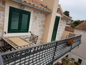 a balcony of a house with green shutters at studio apartman Lanterna in Tribunj