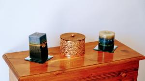three candles sitting on top of a wooden table at Irene Double Apartment Katoi in Symi