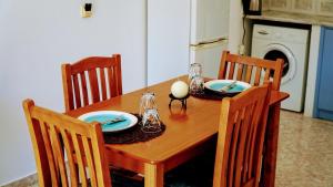 a dining room table with two chairs and a wooden table with plates andoverty at Irene Double Apartment Katoi in Symi