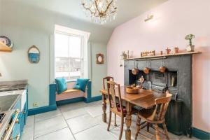 a kitchen with a wooden table and a fireplace at JOIVY Luxury Old Town Apartment in Edinburgh