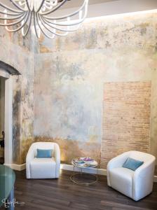 a living room with two chairs and a chandelier at Arcipelago 37 in Cagliari