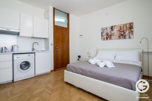 Schlafzimmer mit einem Bett und einer Waschmaschine in der Unterkunft YPA APARTMENTS STORIONE in Padua