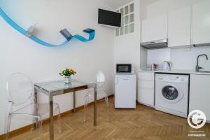 a kitchen with a table and a washing machine at YPA APARTMENTS STORIONE in Padova