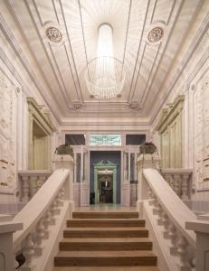 eine Treppe in einem Gebäude mit einem Kronleuchter in der Unterkunft Villa Rosenaw in Rožnov pod Radhoštěm