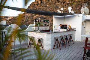 a bar on the roof of a building with stools at Servatur Casablanca Suites & Spa - Adults Only in Puerto Rico de Gran Canaria