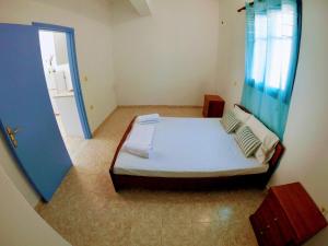 a bedroom with a bed and a blue door at Irene Double Apartment Katoi in Symi
