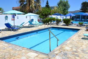 una piscina con sillas y sombrillas en un hotel en Galeana Beach Hotel, en Platanes