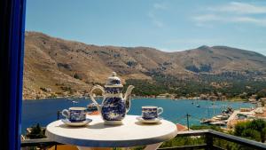 a table with a tea pot and two cups on it at Irene Double Apartment Katoi in Symi