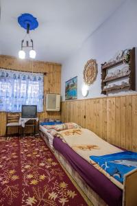 a large room with two beds and a tv at Garan Guesthouse in Jósvafő