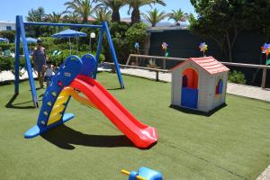 een speeltuin met een glijbaan en een speelhuis bij Galeana Beach Hotel in Platanes