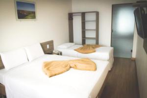 a hotel room with two beds with a robe on them at Dalle Hotel in Bagé