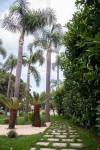 un sentiero con palme in un parco di Boutique Villa Etna d'A'mare a Trecastagni