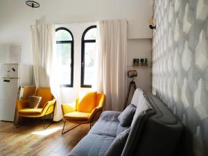 ein Wohnzimmer mit einem Sofa und 2 Stühlen in der Unterkunft Cohen's Jaffa Rooms in Tel Aviv