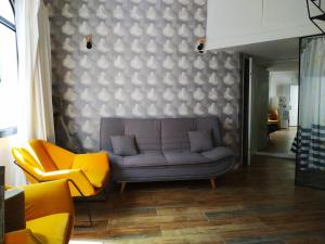 ein Wohnzimmer mit einem Sofa und zwei gelben Stühlen in der Unterkunft Cohen's Jaffa Rooms in Tel Aviv