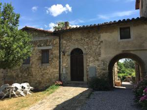 a stone house with two white chairs in front of it at Case Danti Padronale in Santa Fiora