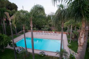 a swimming pool in a yard with palm trees at Boutique Villa Etna d'A'mare in Trecastagni