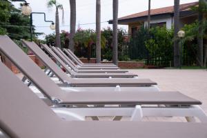 a row of lounge chairs on a patio at Boutique Villa Etna d'A'mare in Trecastagni