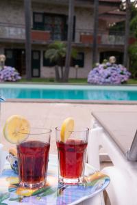 dos vasos de té en una mesa cerca de una piscina en Boutique Villa Etna d'A'mare, en Trecastagni