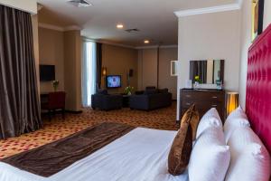 a hotel room with a bed and a living room at Kingsgate Hotel Doha by Millennium Hotels in Doha