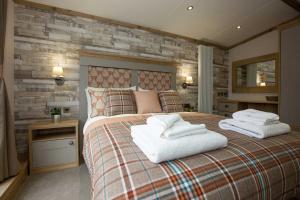 een slaapkamer met een groot bed en handdoeken bij Sandy Balls Holiday Village in Fordingbridge