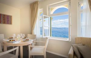 jadalnia ze stołem i dużym oknem w obiekcie Apartments Belvedere - Liburnia w mieście Lovran