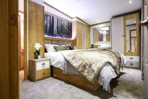 een slaapkamer met een groot bed en een houten muur bij Sandy Balls Holiday Village in Fordingbridge