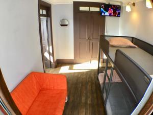 アヴェイロにあるStay In Aveiroの二段ベッド1組とオレンジの椅子が備わる小さな客室です。