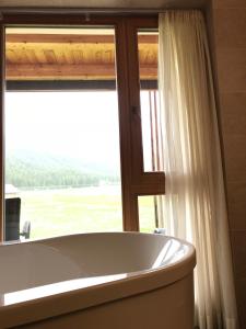 una vasca da bagno seduta di fronte a una finestra di Hotel Schoenblick a Sesto