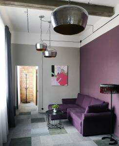 ein Wohnzimmer mit einem lila Sofa und einem Tisch in der Unterkunft Zeit Hotel in Līgatne