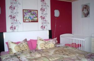 a bedroom with a large bed with pink walls at Ferienhaus-Bender-Rügen in Maltzien
