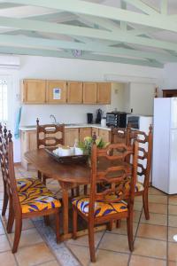 a kitchen with a wooden table and chairs and a refrigerator at Back-Up Power with Stable WiFi! Central in Walmer in Port Elizabeth