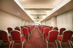 an empty room with red chairs and a screen at favehotel Gatot Subroto Jakarta in Jakarta