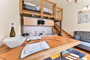 une salle à manger avec une table en bois et des verres à vin dans l'établissement Apartment Nebovidy II - Air Conditioning - Historic City Center, à Prague