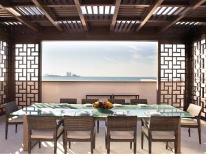 a dining room with a table and chairs and a large window at Jumeirah Al Naseem Dubai in Dubai