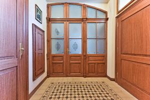 une grande porte en bois dans un couloir avec du carrelage. dans l'établissement Apartment Nebovidy II - Air Conditioning - Historic City Center, à Prague