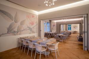 a dining room with tables and chairs and a floral wall at Villa Rosenaw in Rožnov pod Radhoštěm
