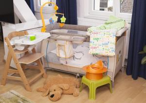 a childs play area with a crib and a table at Wiesental-Lounge in Steinen