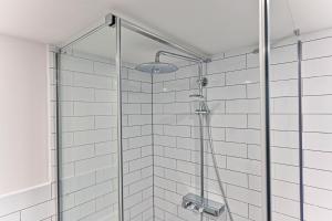 une douche avec une porte vitrée dans une salle de bain dans l'établissement Apartment Nebovidy II - Air Conditioning - Historic City Center, à Prague 8 autres photos