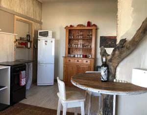 a kitchen with a table and a white refrigerator at Quaint Seaside Cottage in Swakopmund