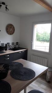 cocina con mesa y reloj en la pared en gîte du haras de valès, en Moult