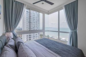 a bedroom with a bed and a large window at 3BR Seaview/HighFloor/Veranda Residence Pattaya in Jomtien Beach