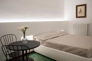 a bedroom with a bed and a table with a vase of flowers at Fanfulla in Monopoli