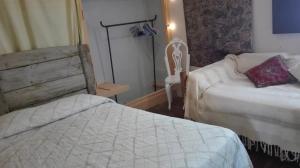 ein Hotelzimmer mit 2 Betten und einem Stuhl in der Unterkunft Refugi Quatre Cases in Clot del Moro