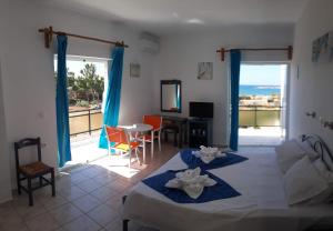 a living room with a bed and a table with chairs at Kalliopi Studios - Apartments in Kato Daratso