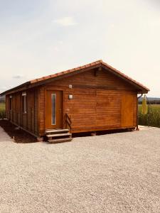 eine kleine Holzhütte mit einer Veranda und einer Tür in der Unterkunft Les Moucherons in Avenches